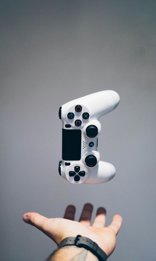 white-sony-ps4-dualshock-controller-over-persons-palm-FJFPuE1MAOM.jpg