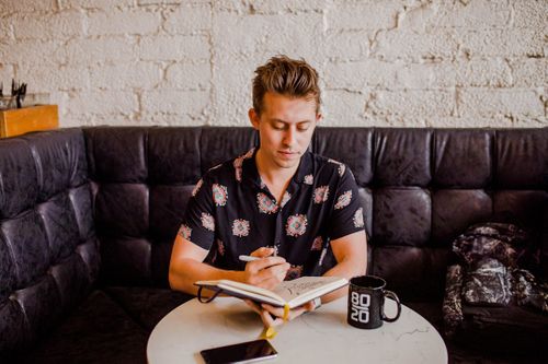 man-sitting-while-holding-an-open-book-FrCAf13JrYg.jpg