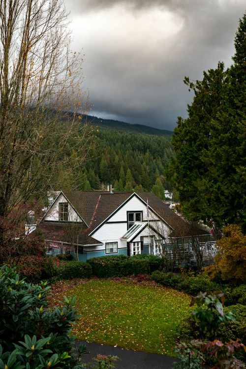 white-and-black-house-surrounded-by-trees-under-cloudy-sky-during-daytime-Hyn-ujrF43E.jpg